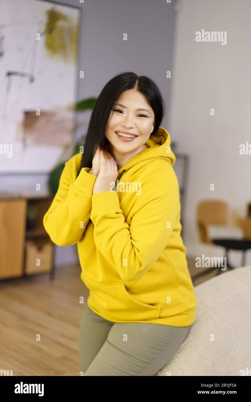 Reife asiatische Frau wird in ihrem Zuhause gefangen gehalten und genießt die glücklichen Momente des Lebens durch die Linse des Lebensstils Biohacking. Das ist sie Stockfoto