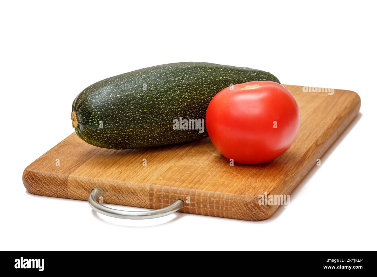 Tomate und Zucchini auf dem Holzschneidebrett. Stockfoto