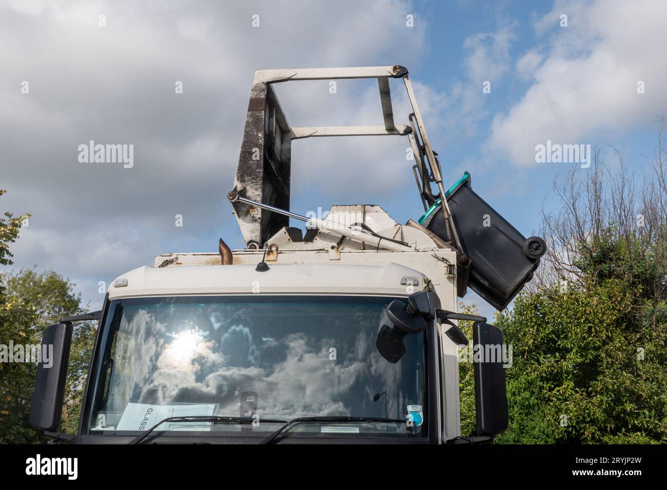 Der Glasbehälter wird in einen Veolia Müllwagen (Müllcontainer-LKW), Großbritannien, geleert Stockfoto