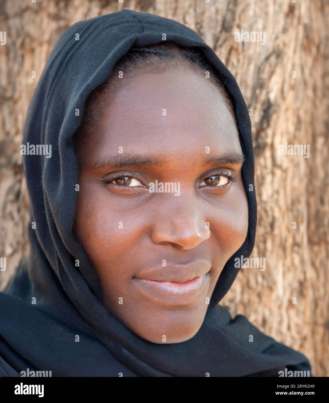 muslimische afrikanische junge Frau mit schwarzem Schal, Kopfschuss im Freien tagsüber Stockfoto