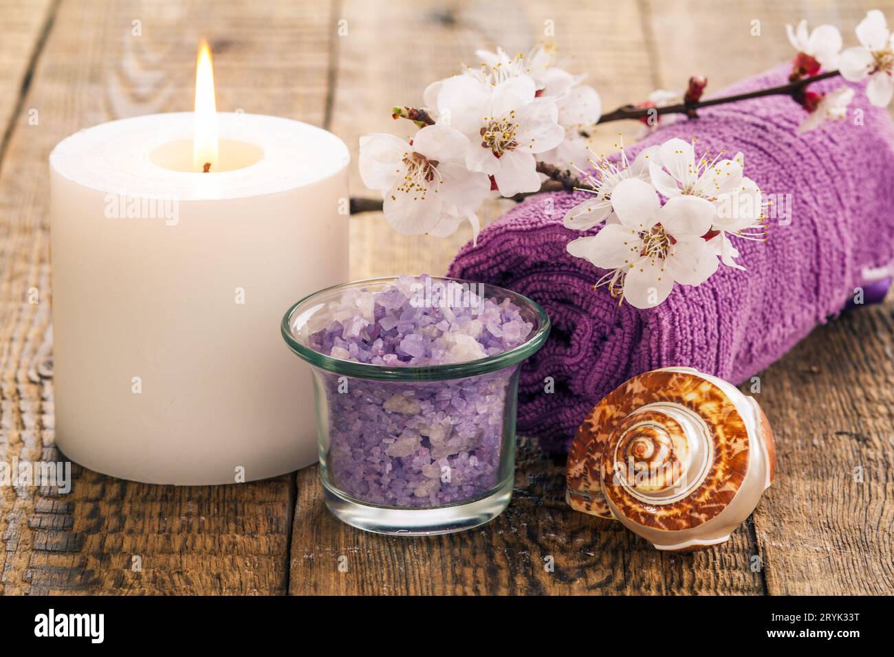 Meersalz, Seife mit Handtuch, Muschel und brennende Kerze mit blühendem Zweig. Stockfoto