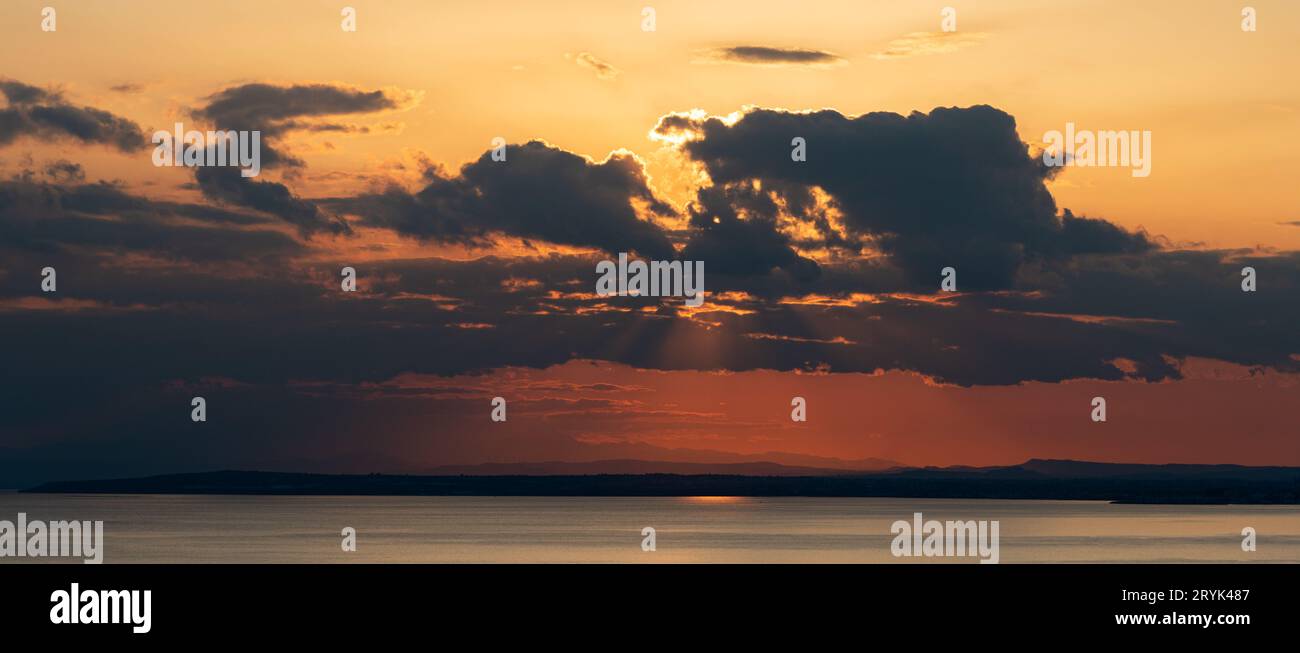 Farbenfroher Sonnenuntergang mit hellem Licht im Meer. Ende des Tages. Friedliche, ruhige Meereslandschaft Stockfoto