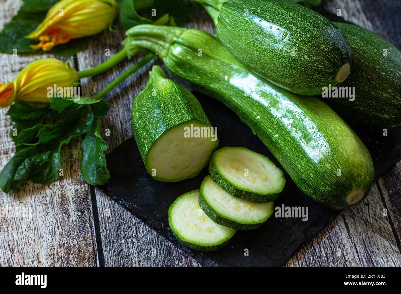 Ernte von Zucchini. Gesunde, ungekochte, frische, grüne Zucchini auf einem hölzernen Küchentisch. Stockfoto