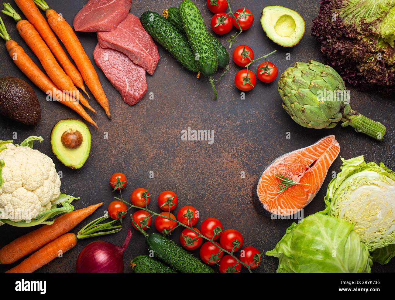 Verschiedene rohe Lebensmittel: Gemüse, Rindfleischsteak, Fisch Lachsfilet auf dunkel rustikal braunem Steintisch mit Blick auf Kopierraum. Stockfoto