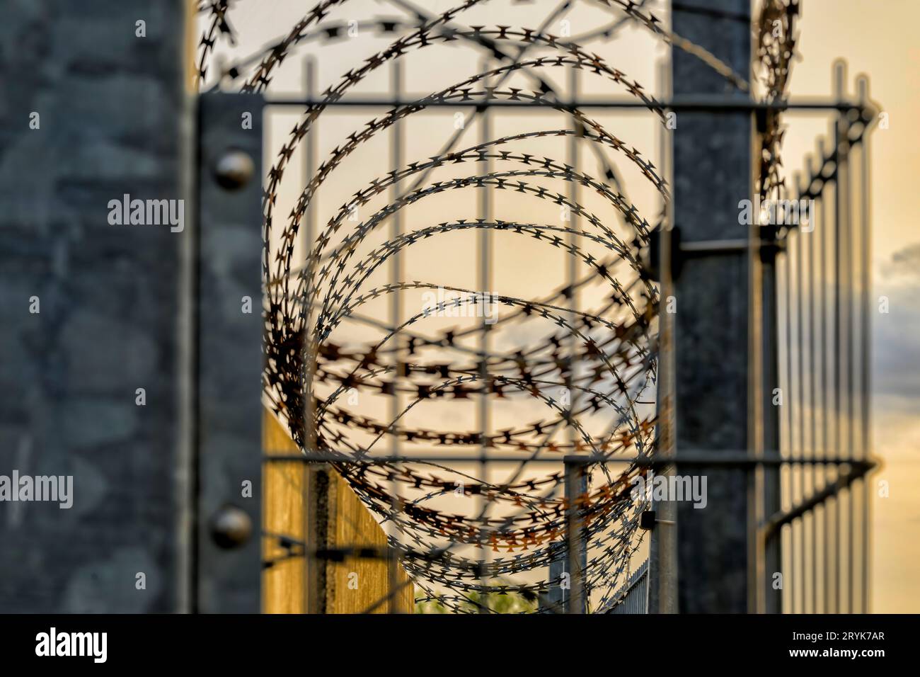 Absperrung durch eine Mauer, Zaun und Stacheldraht Stockfoto