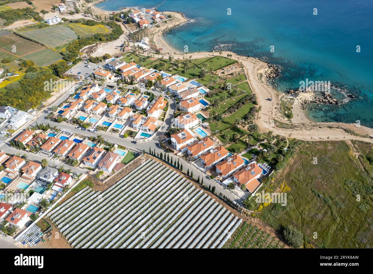 Drohnen aus einem Feriendorf mit Luxushäusern an einer idyllischen felsigen Küste. Sommerurlaub am Meer. Stockfoto