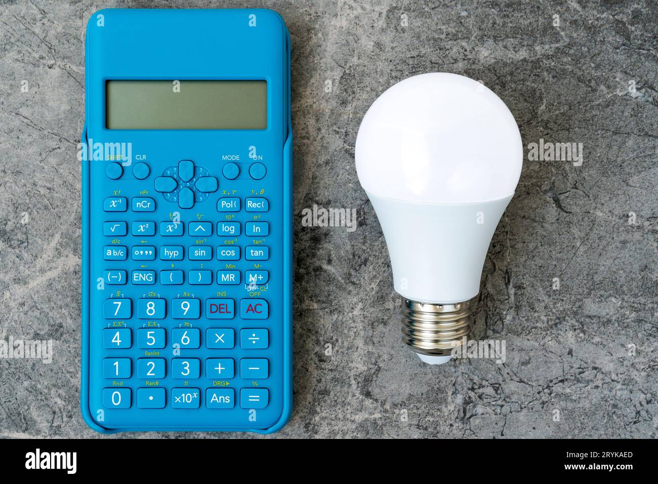 Energieeffiziente Glühlampe und blauer moderner Taschenrechner Stockfoto