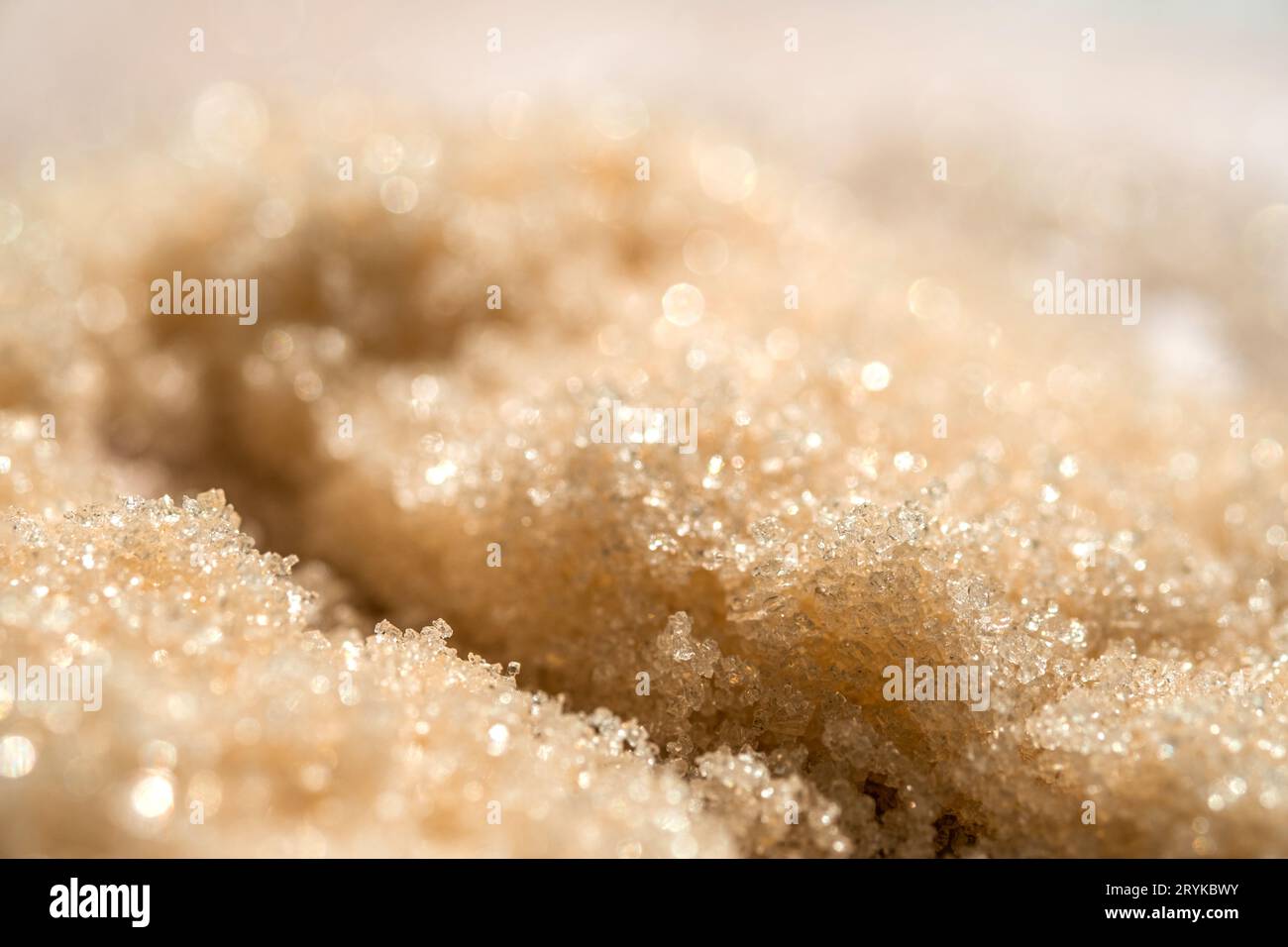 Die Textur eines gelb glänzenden Peelings auf beigefarbenem Hintergrund. Stockfoto