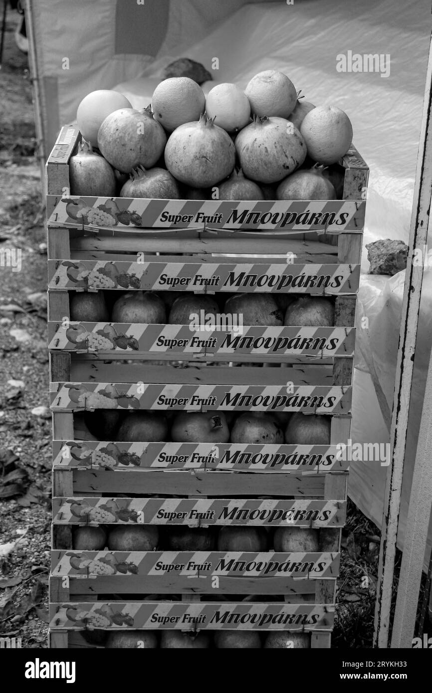 Schwarz-weißer Turm mit acht Kisten Orangen und Granatapfel. Die Kisten haben vorne ein Streifenmuster und oben die Früchte Stockfoto