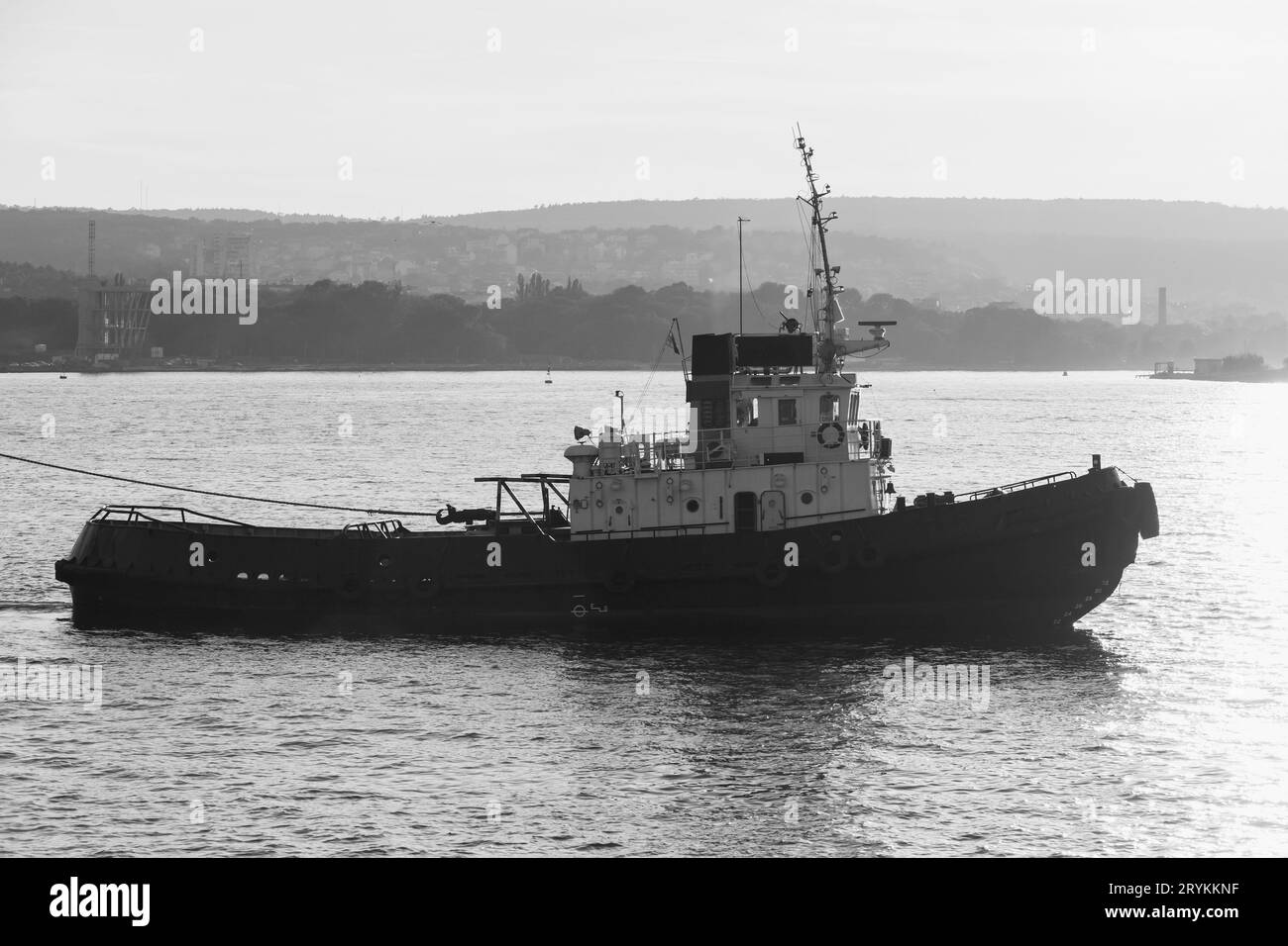 Schlepper ist unterwegs. Schwarzes Meer, Hafen von Varna, Bulgarien. Schwarz-weiß-Silhouettenfoto Stockfoto