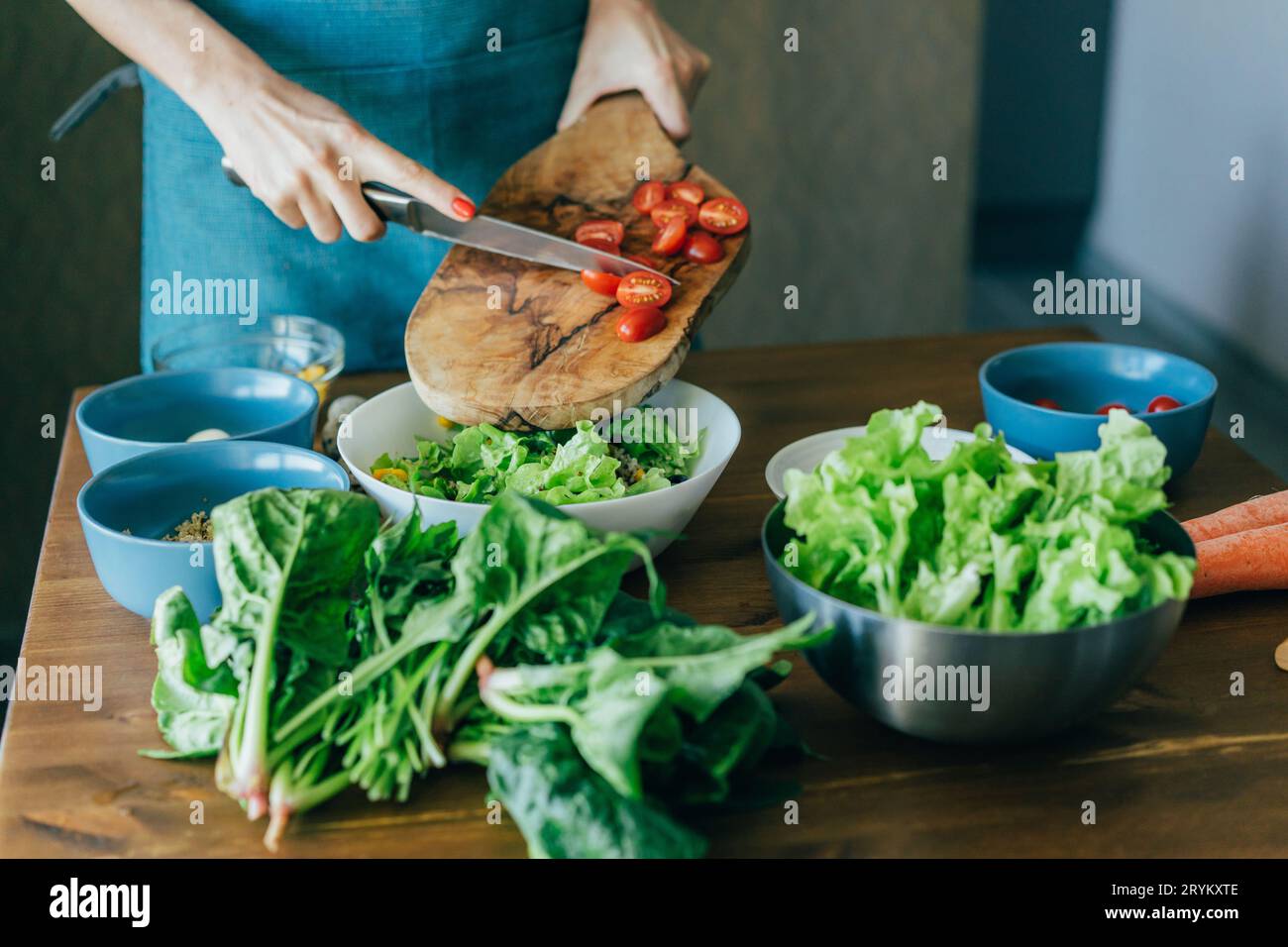 Eine nicht erkennbare weibliche Hand bereitet einen Salat zu und gibt die Zutaten in eine große Schüssel. Wie man ein mageres Mittelmeer zubereitet Stockfoto