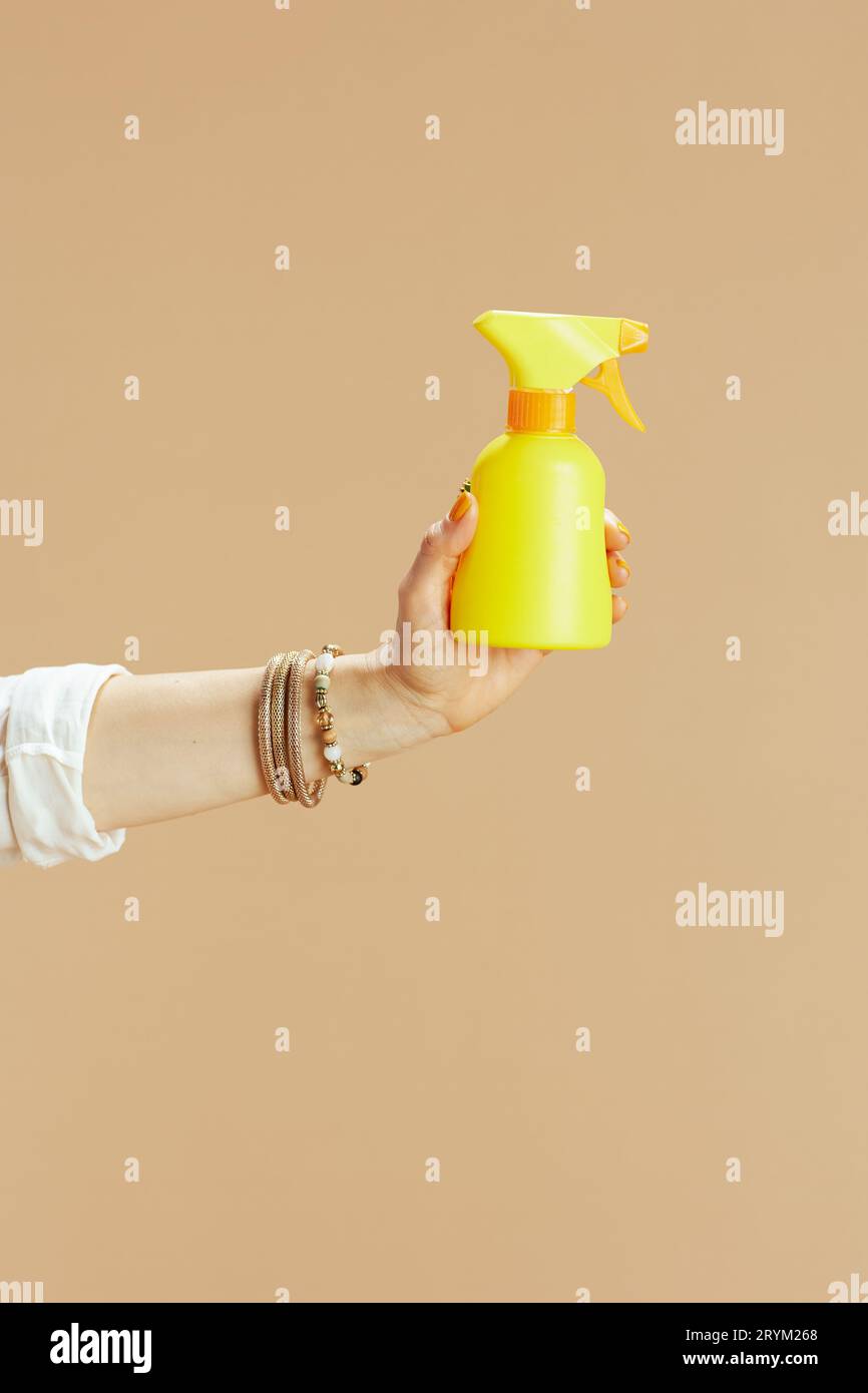 Strandurlaub. Nahaufnahme einer Frau isoliert auf Beige mit Sonnencreme. Stockfoto Strandurlaub. Nahaufnahme einer Frau isoliert auf Beige mit Sonnencreme. Stockfoto