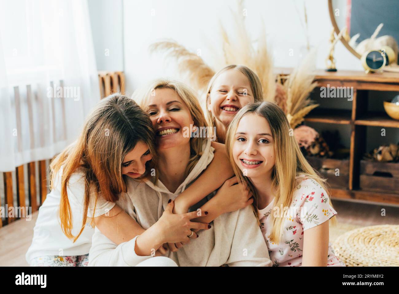 Spielerische glückliche lachende Töchter umarmen ihre Mutter. Familienporträt Stockfoto