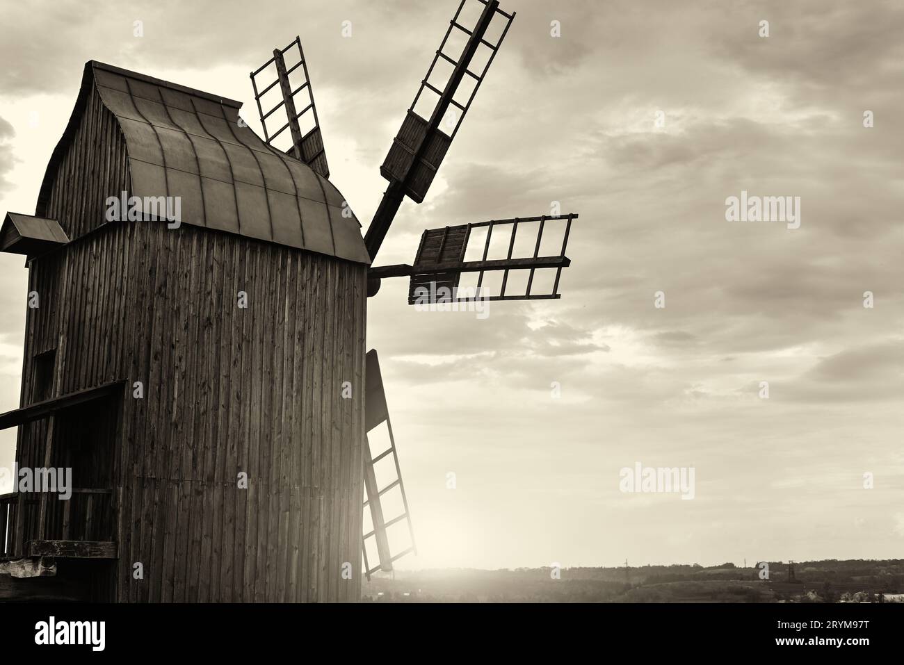 Alte Windmühle steht allein auf dem Feld mit dem blauen Himmel auf dem Hintergrund mit Copyspace. Retro f Stockfoto