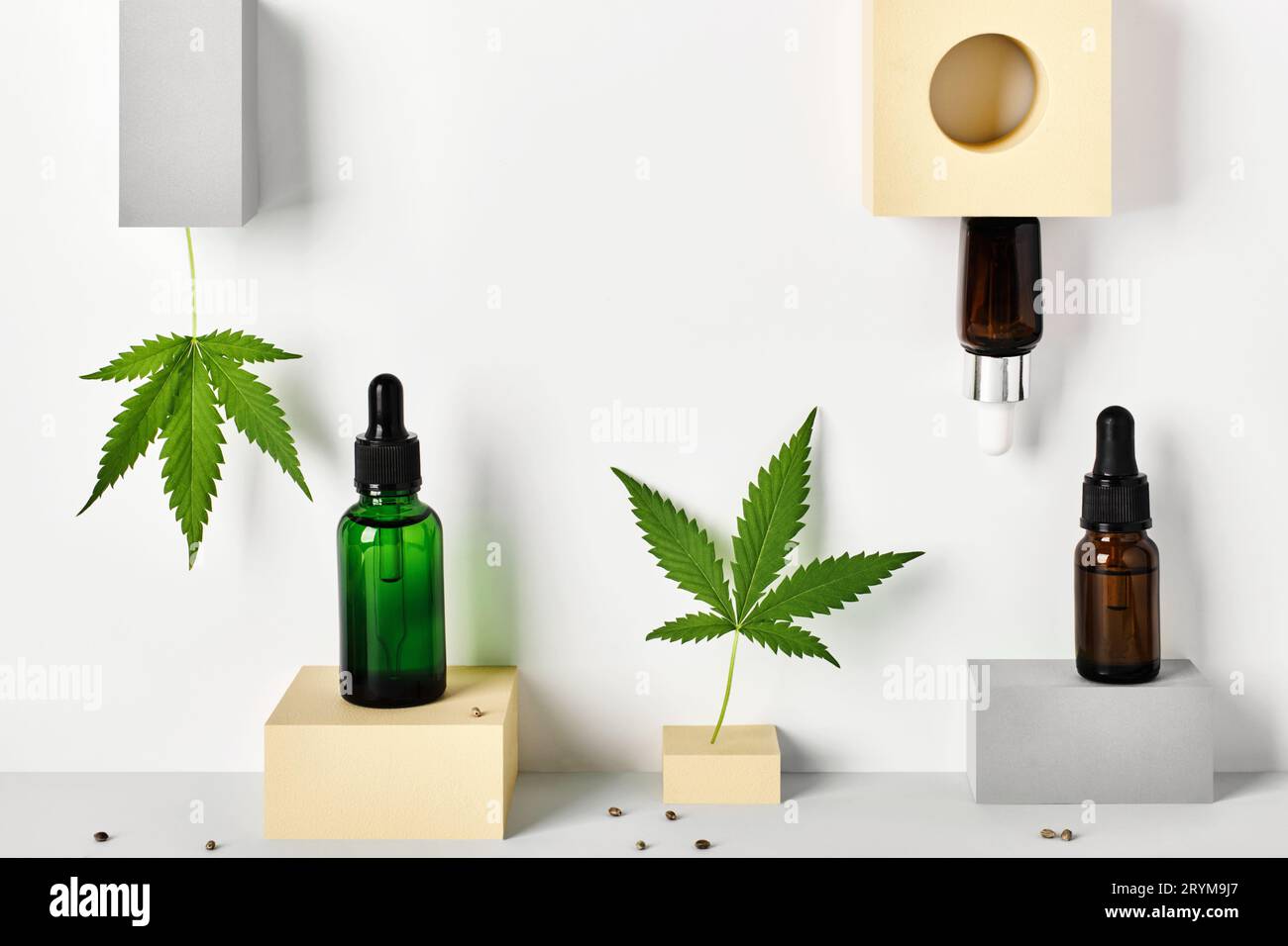 Verschiedene Glasflaschen mit CBD-Öl und Cannabisblättern auf abstrakten geometrischen Podesten. CBD-Öl-Konzept für Kosmetik Stockfoto