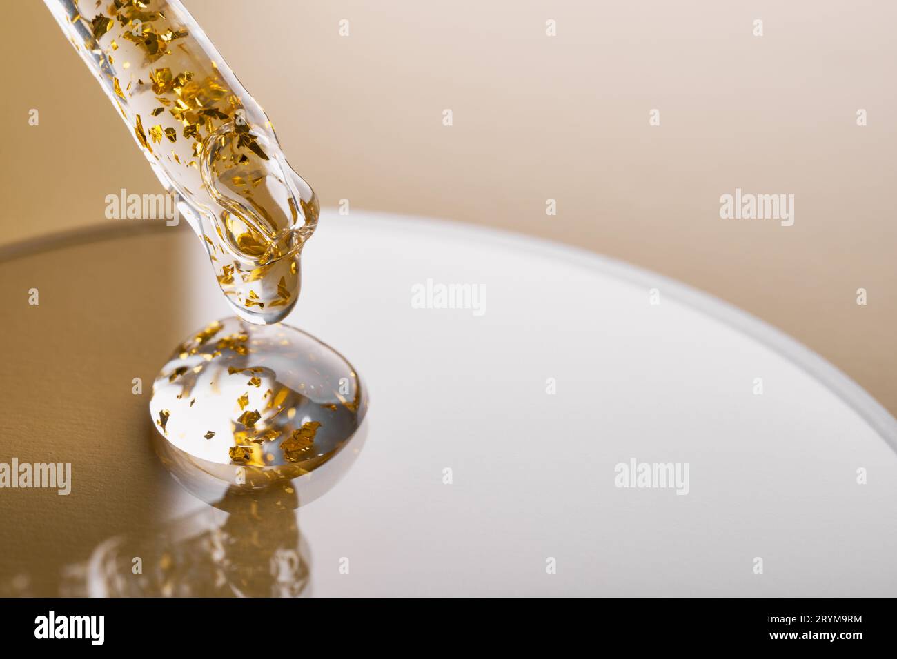 Pipetten- und Gelkosmetikprodukte mit Gold in einer Petrischale auf beigefarbenem Hintergrund Stockfoto