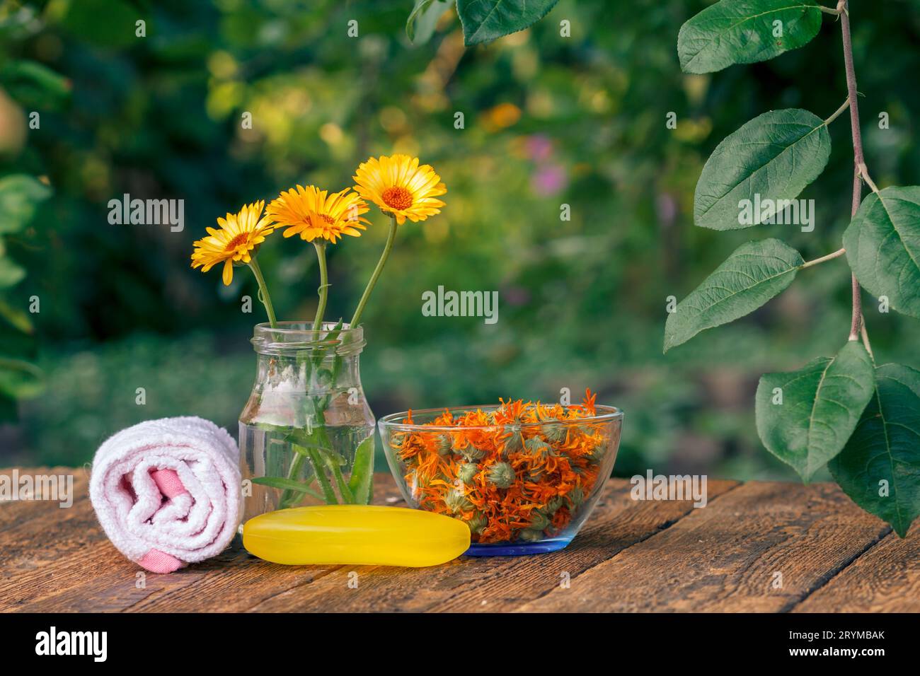 Seife mit Ringelblumenextrakt, einem Handtuch, Ringelblumen in einem Glas und einer Schüssel. Stockfoto