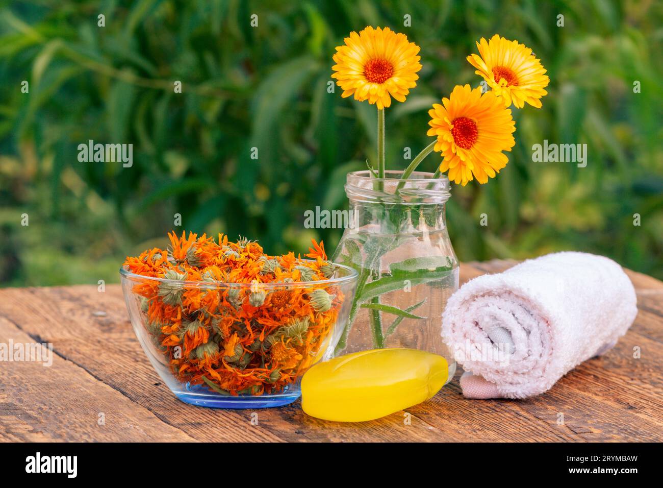 Handtuch, Seife mit Ringelblumenextrakt, Ringelblumen und eine Schüssel mit trockenen Blüten Stockfoto
