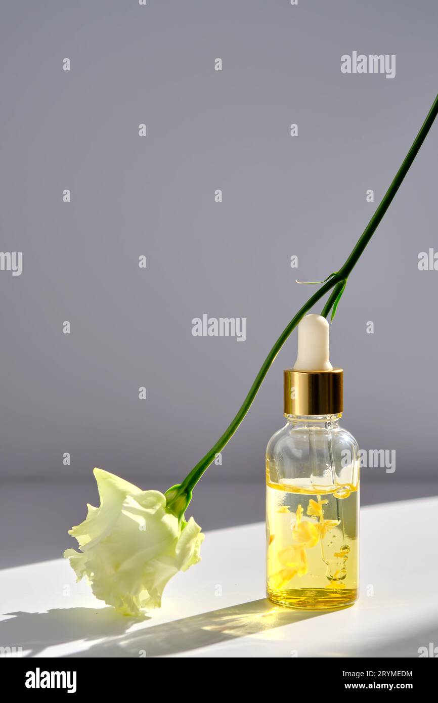 Serum mit gelben Blütenblättern und einer zarten Blume. Stockfoto