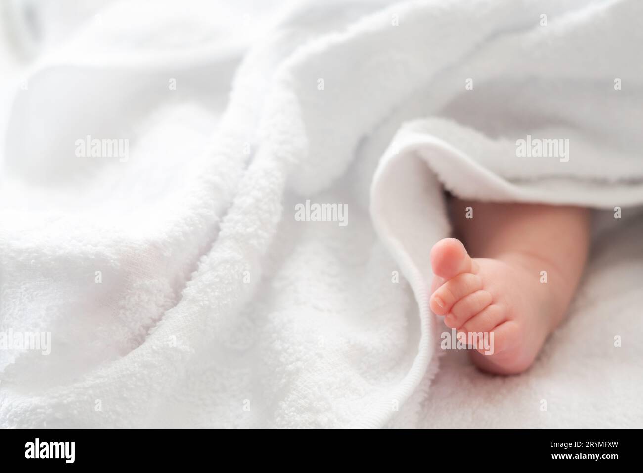 Zarte Zehenpartie: Der Neugeborenenfuß wird sanft von einer weißen Hülle umschlossen Stockfoto