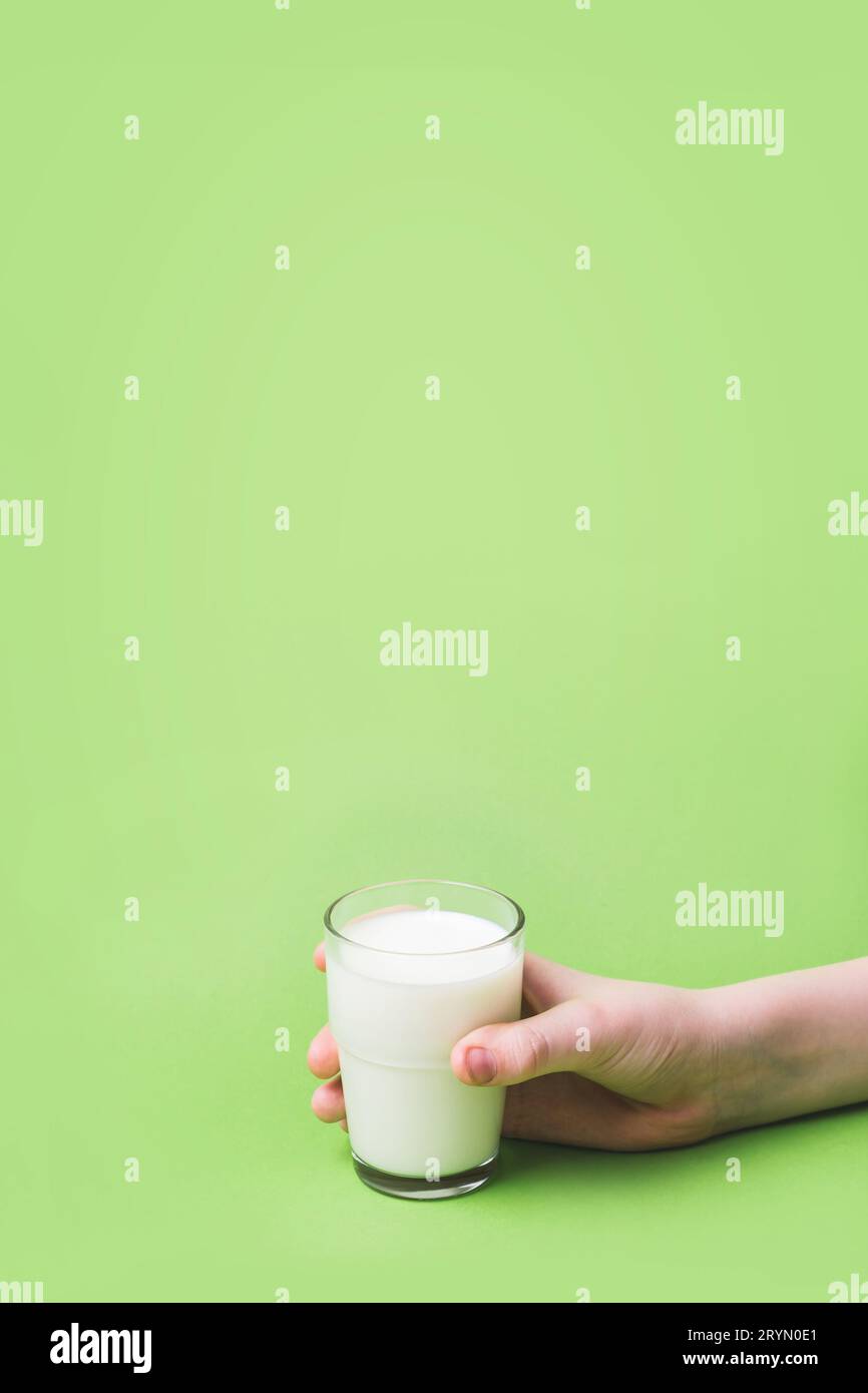 Die Kinderhand hält ein Glas Milch. Gesundheit, Ernährung und Ernährungskonzept Stockfoto