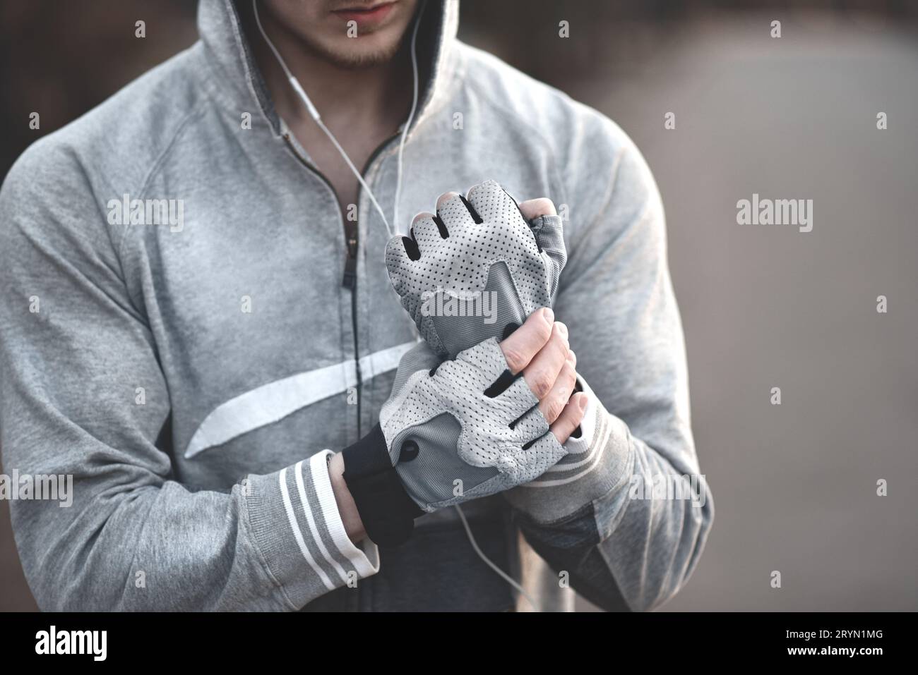 Nahaufnahme, der Sportmann legt sich Handschuhe an die Hände, bevor er trainiert. Stockfoto