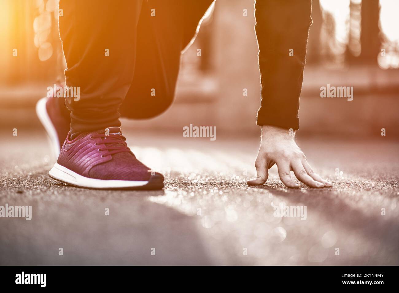 Zugeschnittenes Bild von Händen, die Schnürsenkel auf dem Sneaker binden, laufender Oberfläche im Hintergrund. Sportler, der sich vor einem Sporttraining ausdehnt Stockfoto