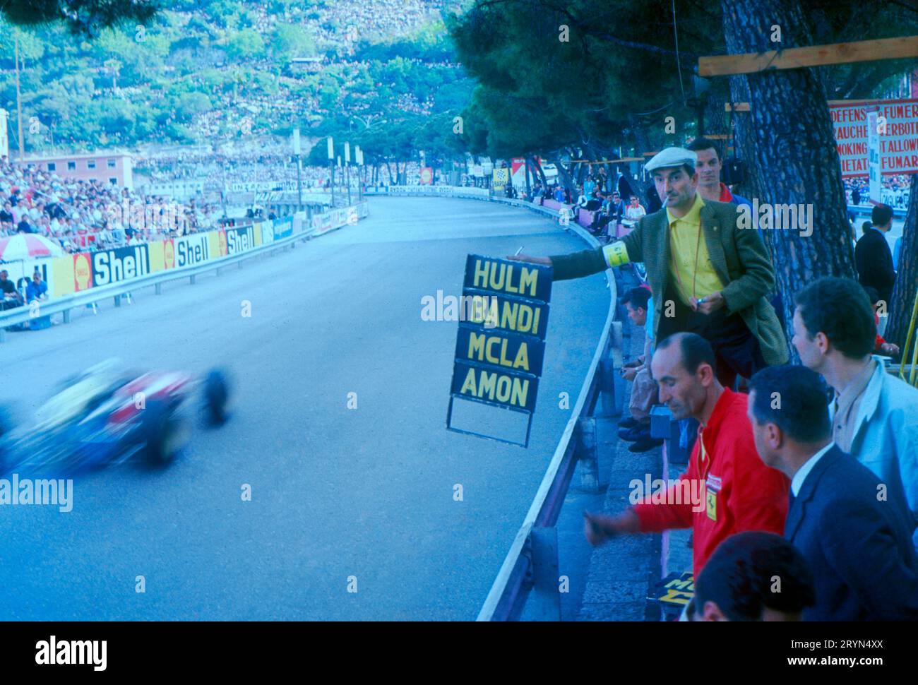Grand Prix Von Monaco 1967. Franco Lini, ein Reporter, der von Enzo Ferrari als Teammanager gerufen wurde, signalisiert Bandinis Position hinter Hulme und vor MCL Stockfoto