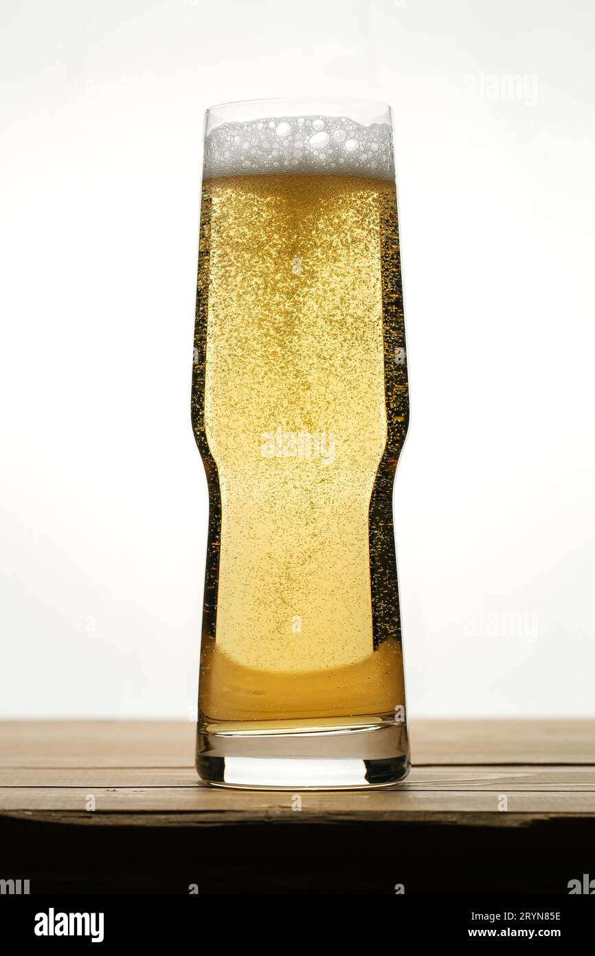 Goldenes Bier mit Blasen in einem transparenten Glas. Stockfoto