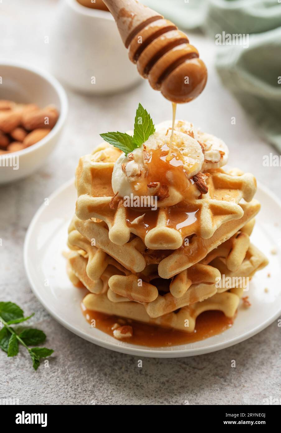 Belgische Waffeln mit Obst, Bananen und Honig. Hausgemachtes Backen. Konzept des gesunden Frühstücks. Stockfoto