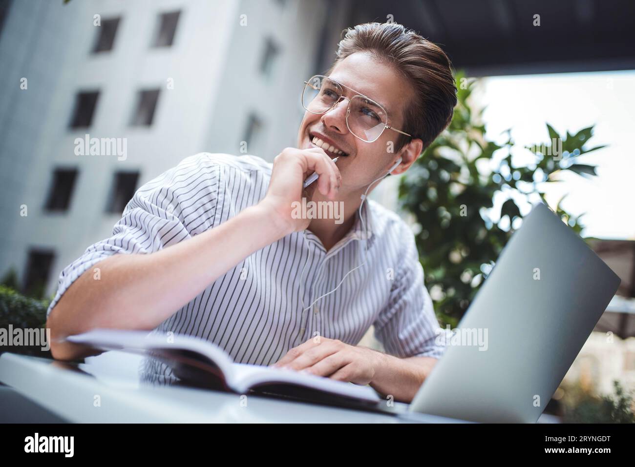 Clevere Einstellung. Ein schöner Mann, der einen Laptop benutzt und im Café sitzt, während er im Internet surft. Junge Blogger oder journa Stockfoto