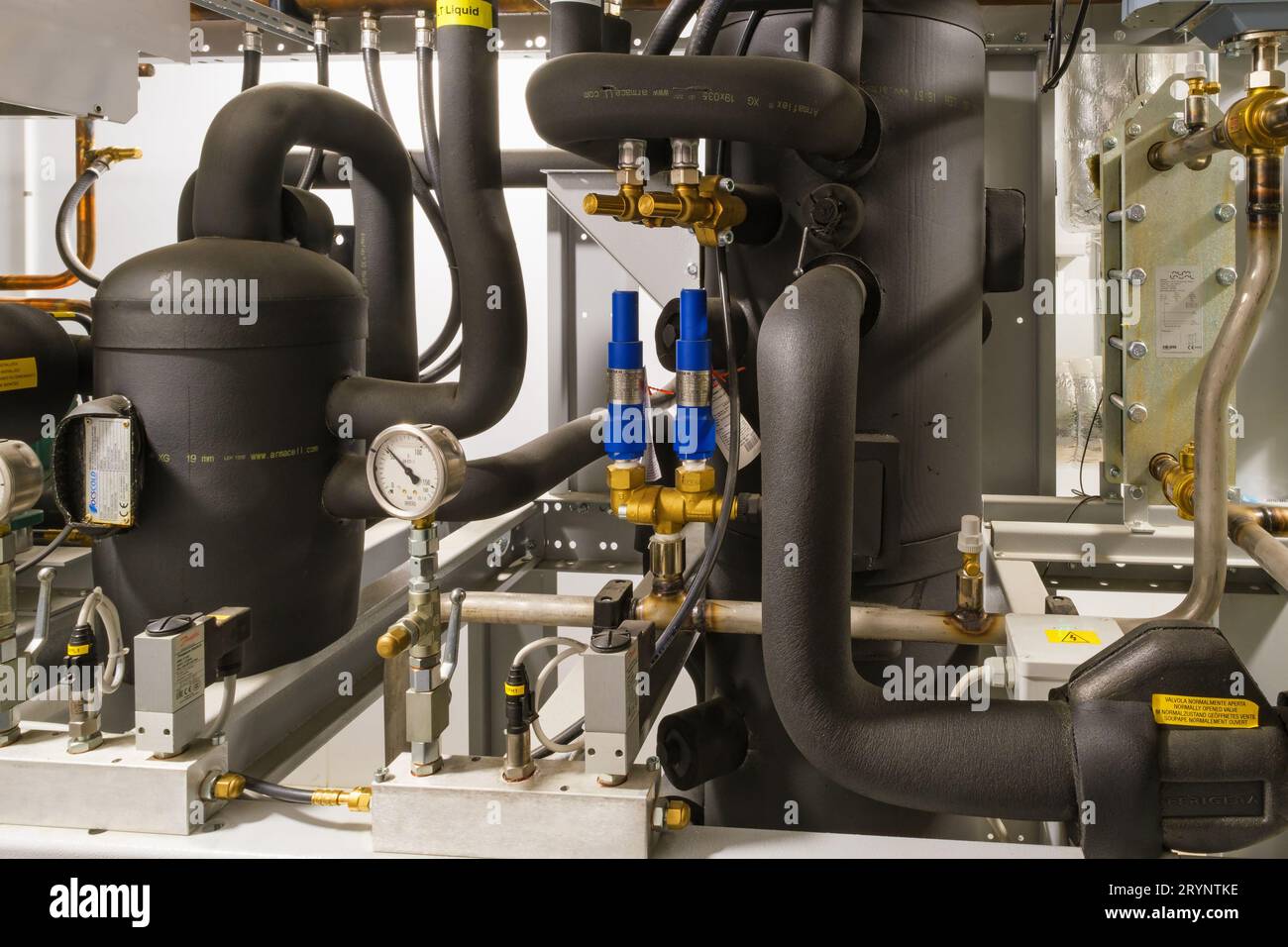 Isolierte Rohre und Manometer an einer Maschine Stockfoto