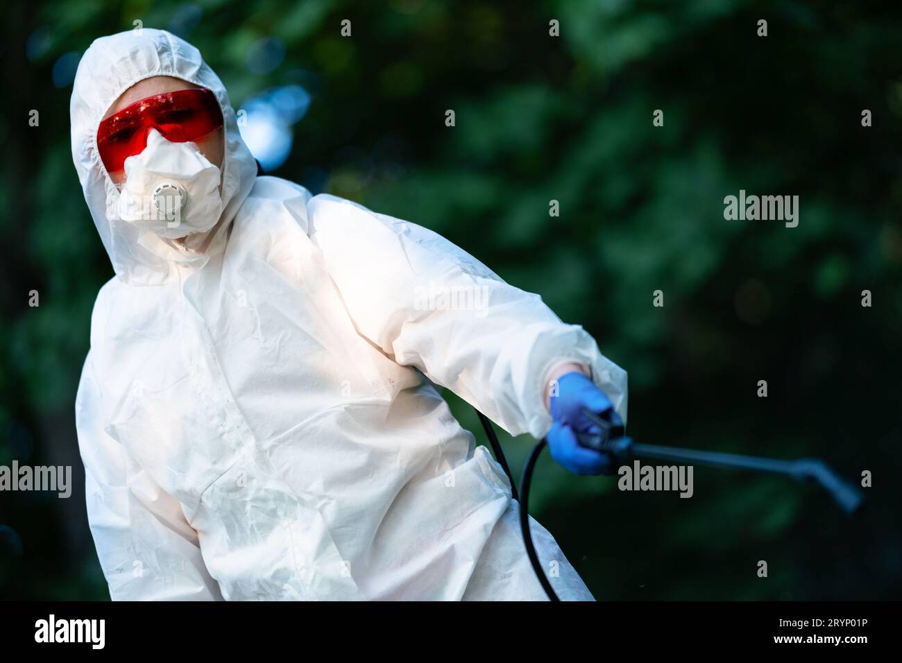 Ein Arbeiter sprüht Pestizide in einem offenen Park. Schädlingsbekämpfung Stockfoto