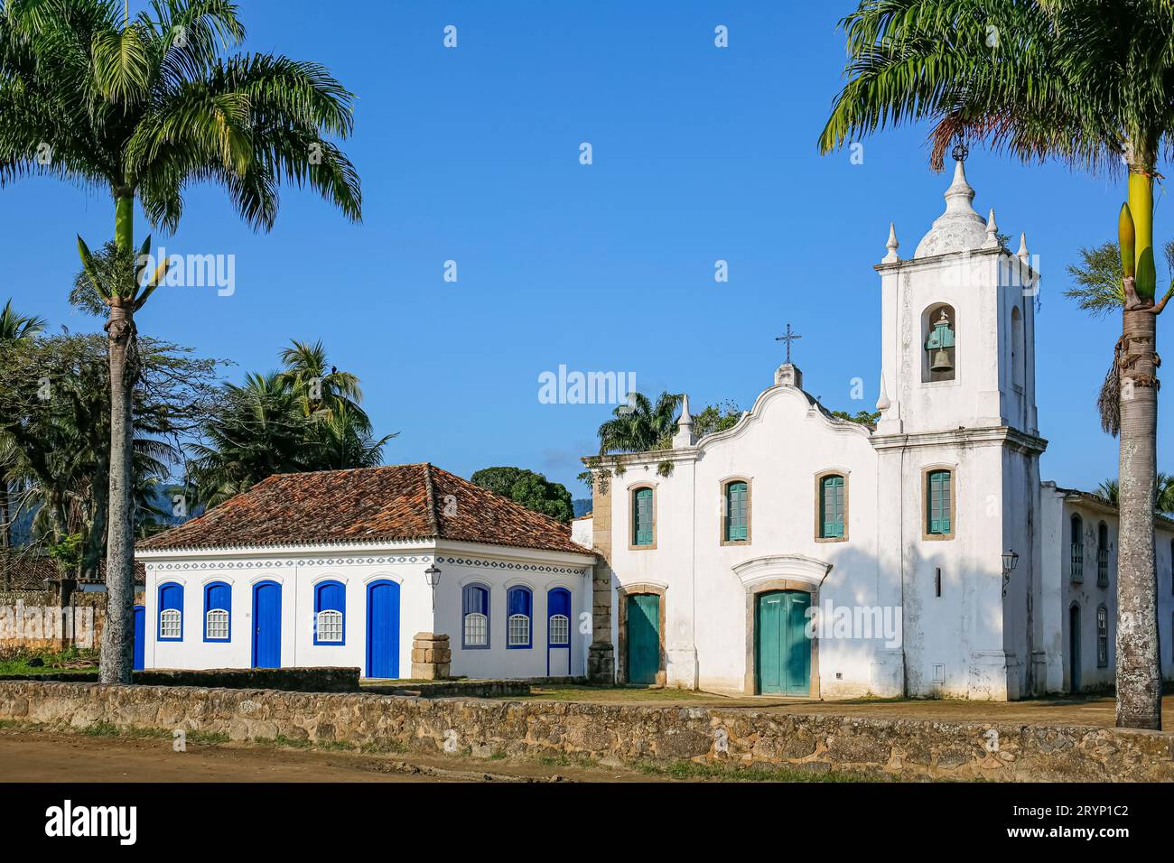 Kirche Nossa Senhora das Dores mit zwei Palmen an einem sonnigen Tag, historisch Stockfoto