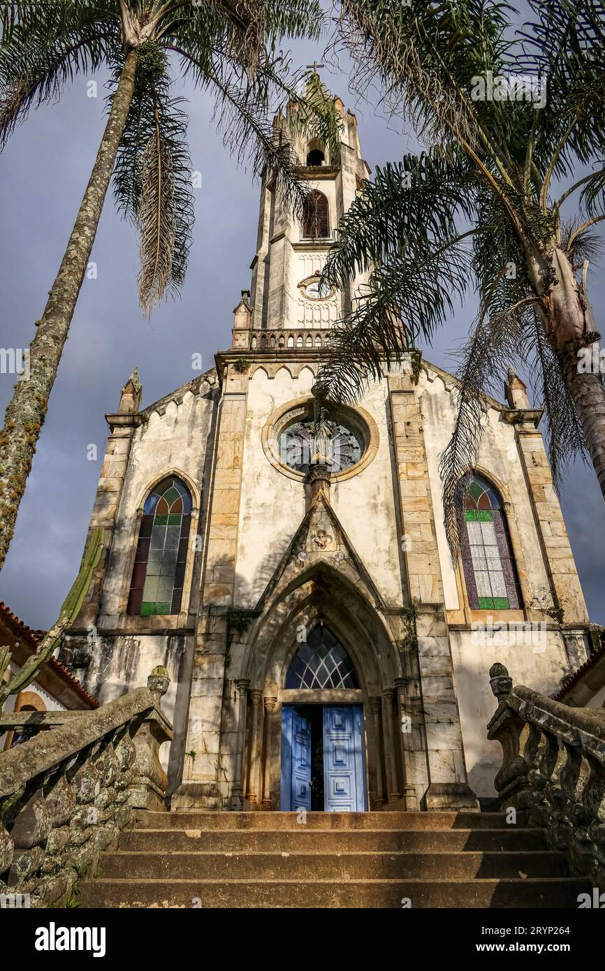 Vorderansicht der Kirche mit Palmen im Sonnenlicht, Sanctuary Caraca, Minas Gerais, Brasilien Stockfoto