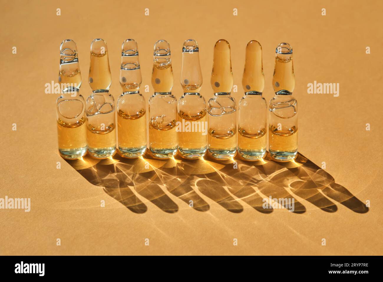 Glasampullen auf beigefarbenem orangefarbenem Hintergrund. Stockfoto