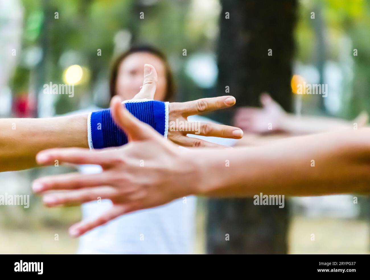 Die Hände der Menschen werden im Park Yoga erzogen Stockfoto