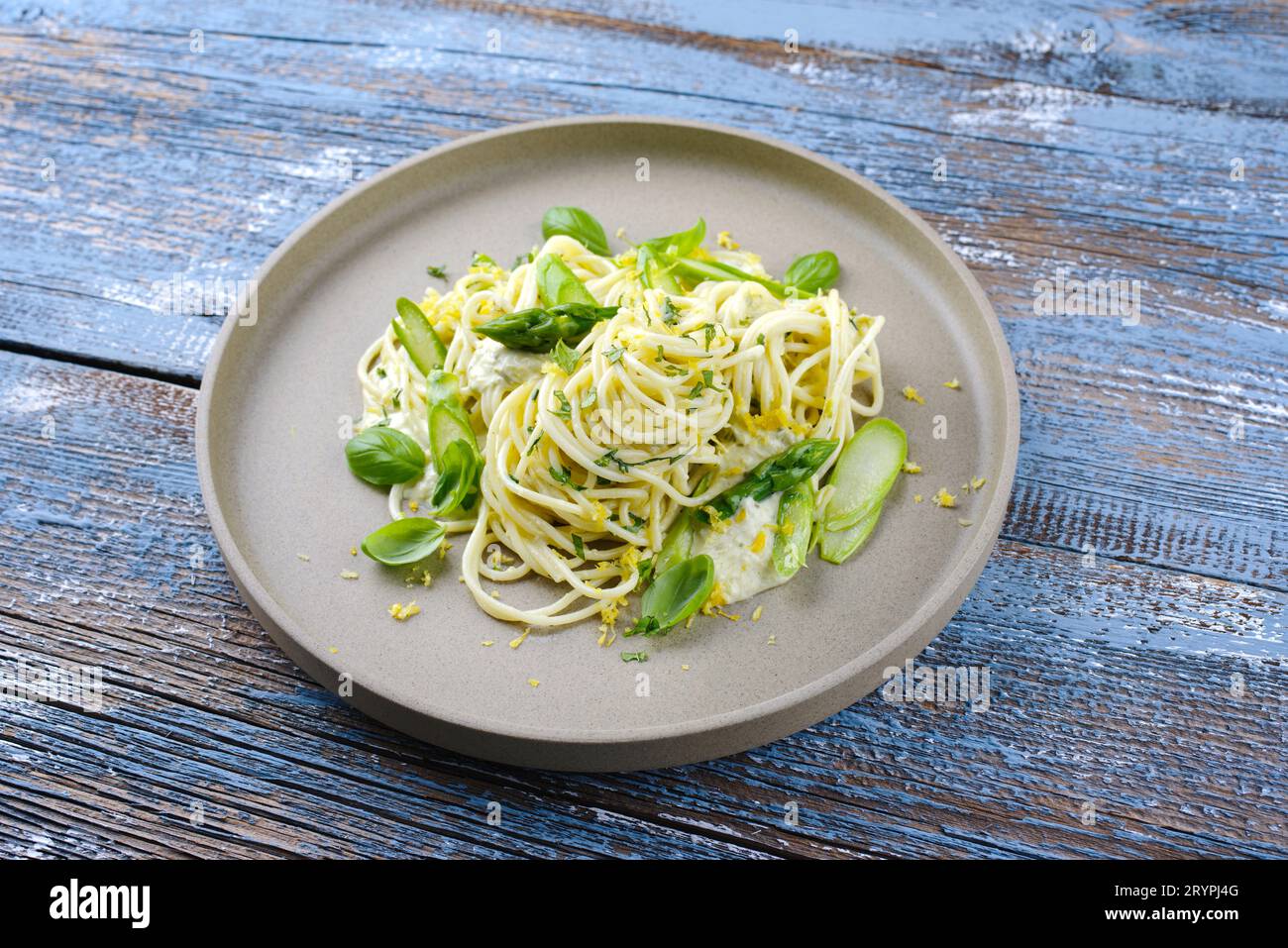 Traditionelle italienische Spaghetti mit Spargel in Kräutersauce, serviert als Nahaufnahme auf einem Teller im Nordic Design Stockfoto