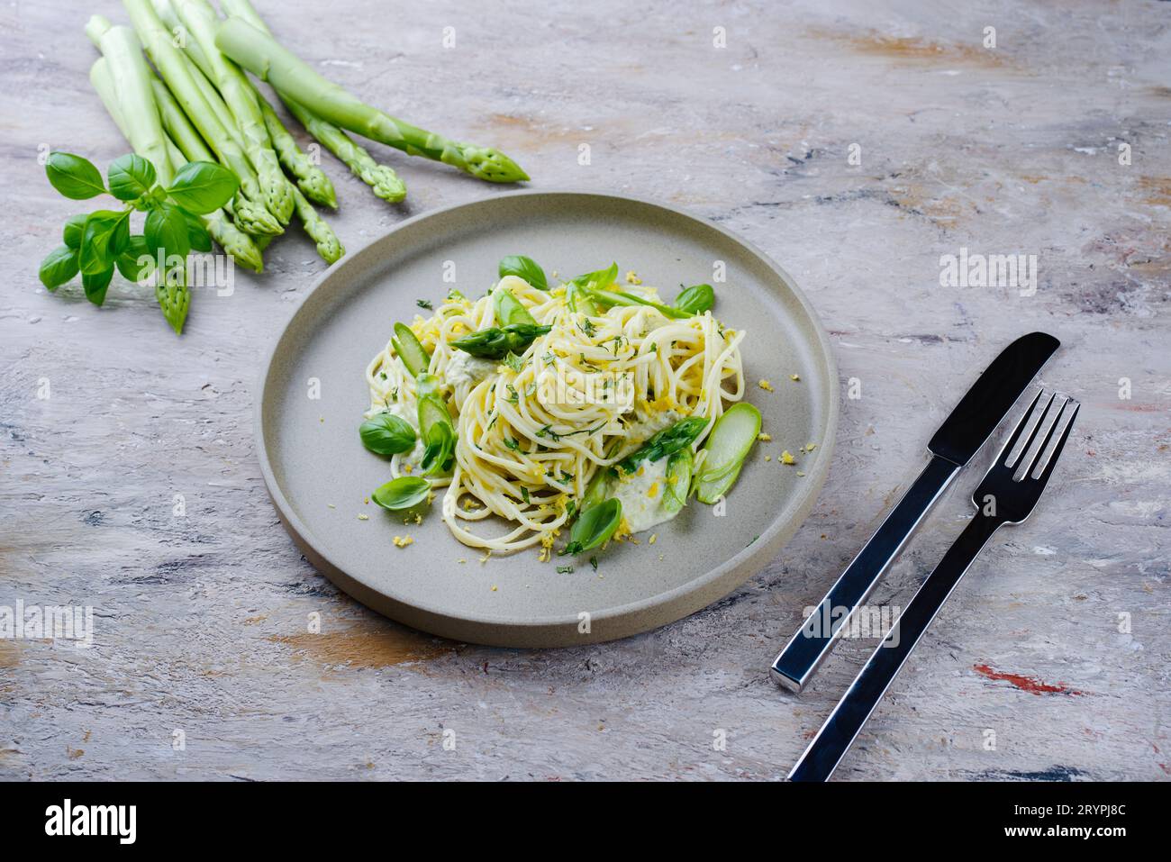Traditionelle italienische Spaghetti mit Spargel in Kräutersauce, serviert als Nahaufnahme auf einem Teller im Nordic Design Stockfoto