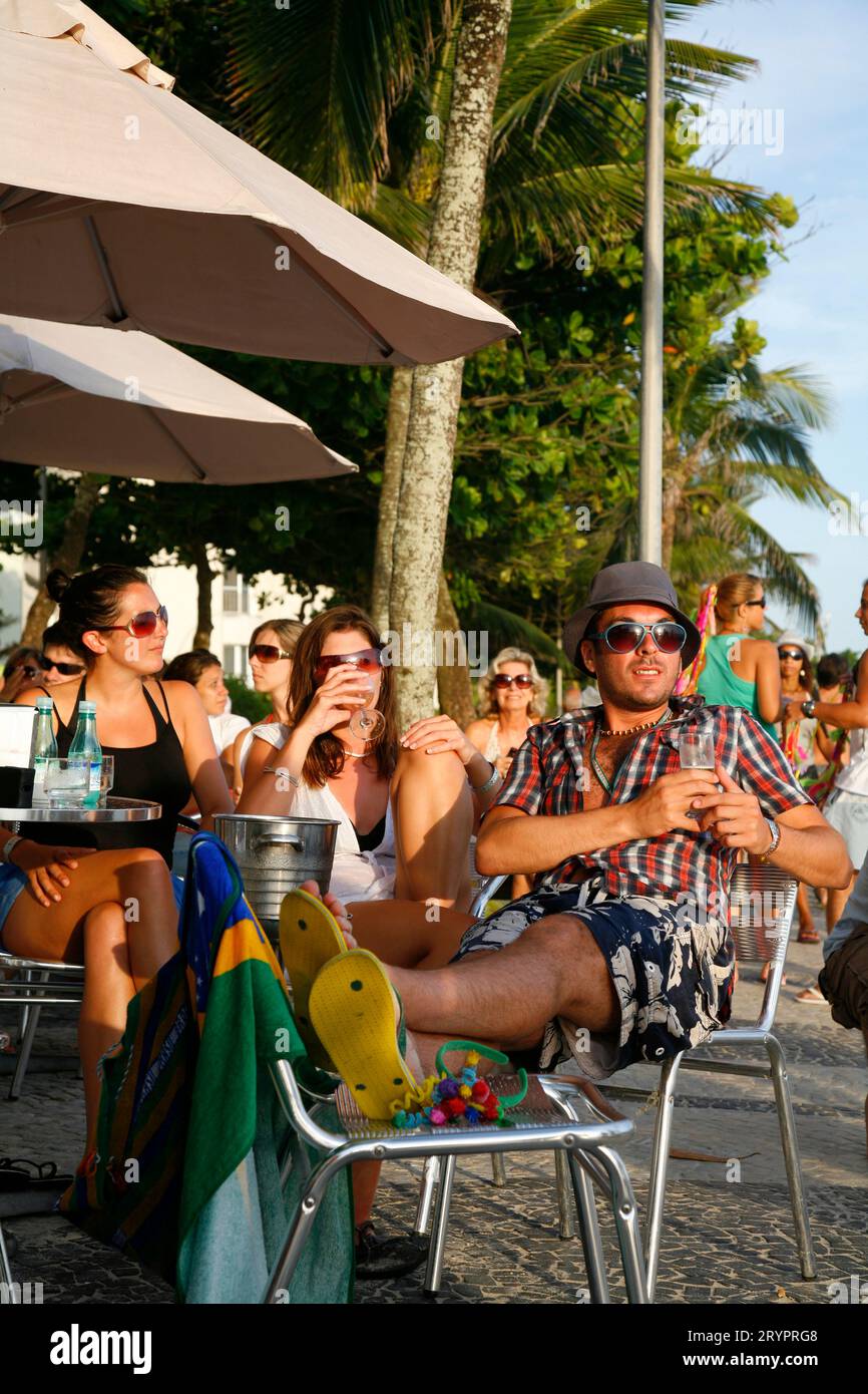 Menschen sitzen in einem Café an der Strandpromenade von Arpoador Beach, Rio De Janeiro, Brasilien. Stockfoto