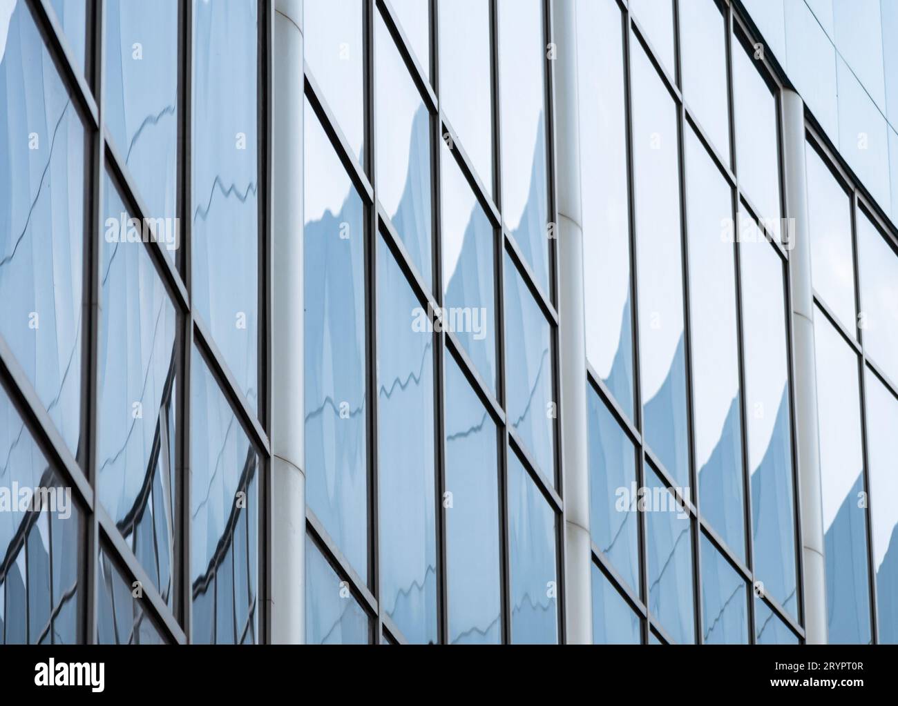Abstrakter Hintergrund spiegelt sich in den Glasfenstern des Gebäudes wider Stockfoto