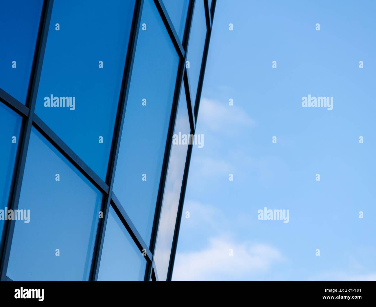 Fragment eines Fensters eines hohen Bürogebäudes vor blauem Himmel Stockfoto