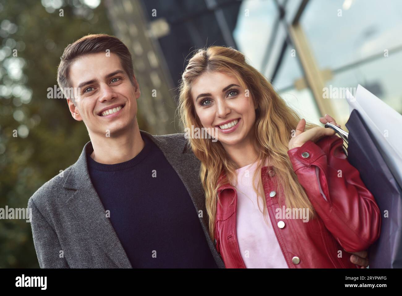 Schöne junge Liebende paar Durchführung Einkaufstüten und gemeinsam genießen. Bild junges paar Shopping in der Stadt. Stockfoto