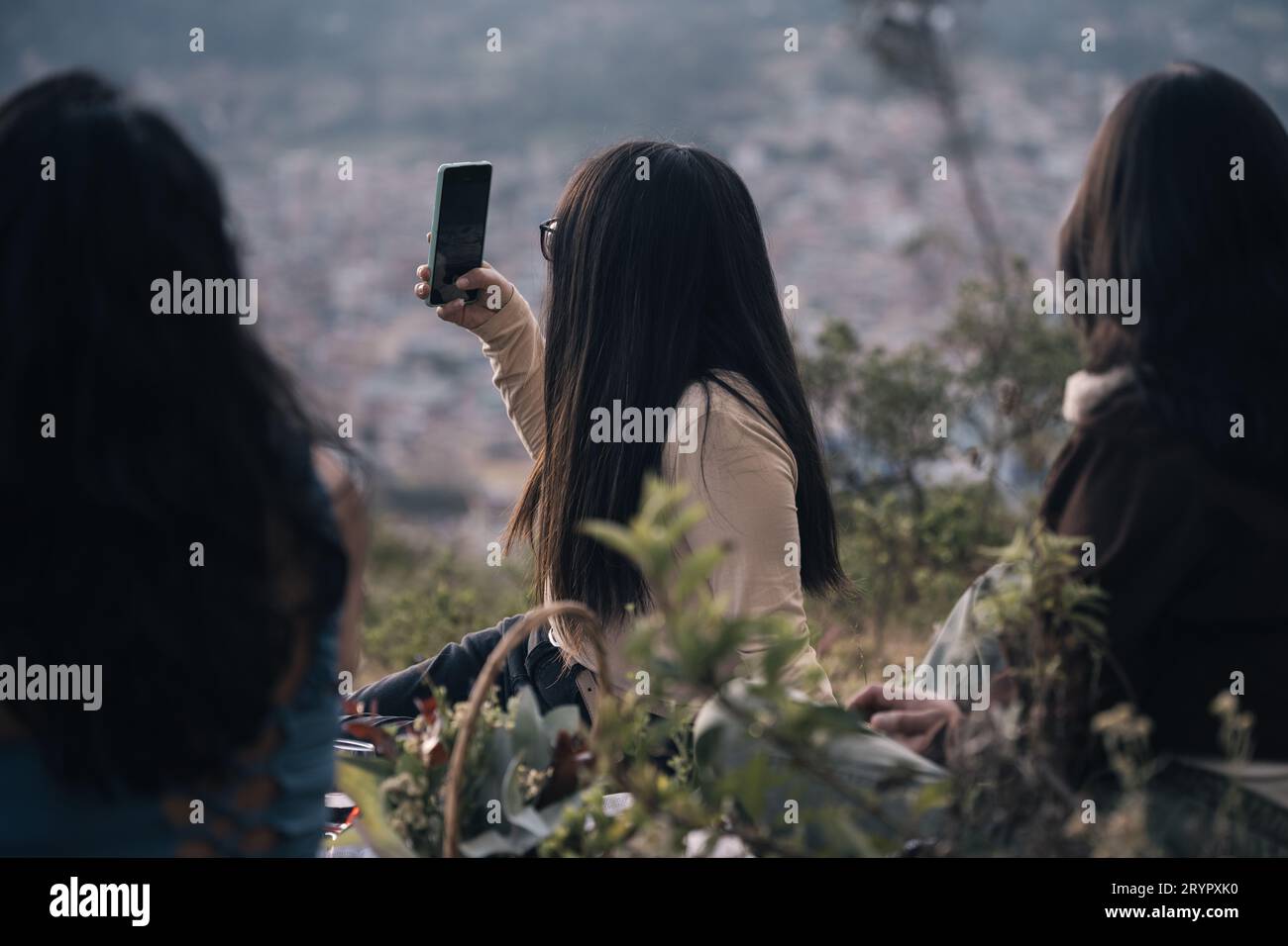Blick von hinten auf Frauen, die bei Sonnenuntergang ein Selfie in der Natur machen Stockfoto