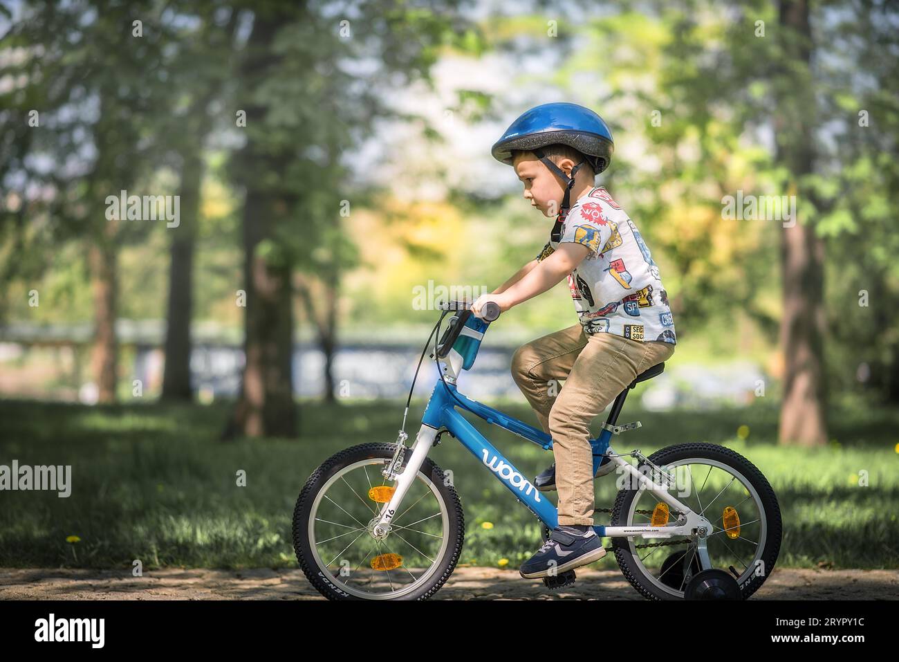 Kleiner Junge, der im Park Fahrrad fährt. Stockfoto