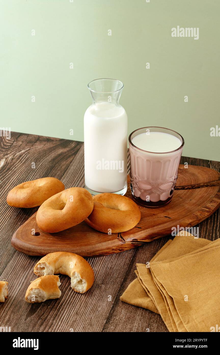 Milch und Bagels auf einem Holztisch Stockfoto