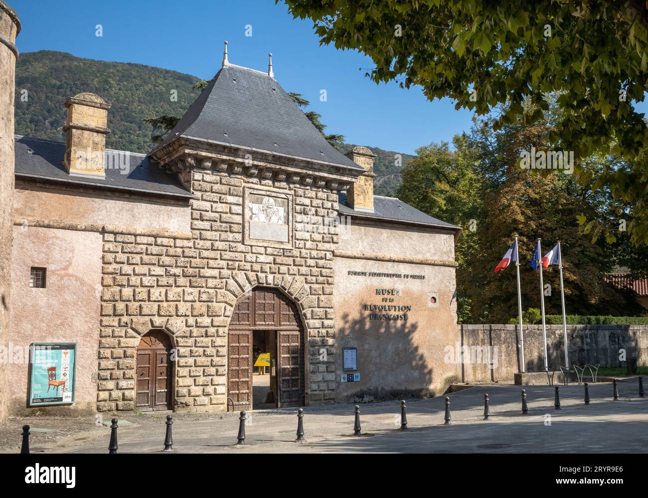 Französische und EU-Flaggen fliegen neben dem Haupteingang des Schlosses, in dem sich das Museum der Französischen Revolution, Vizille, Frankreich befindet. Stockfoto