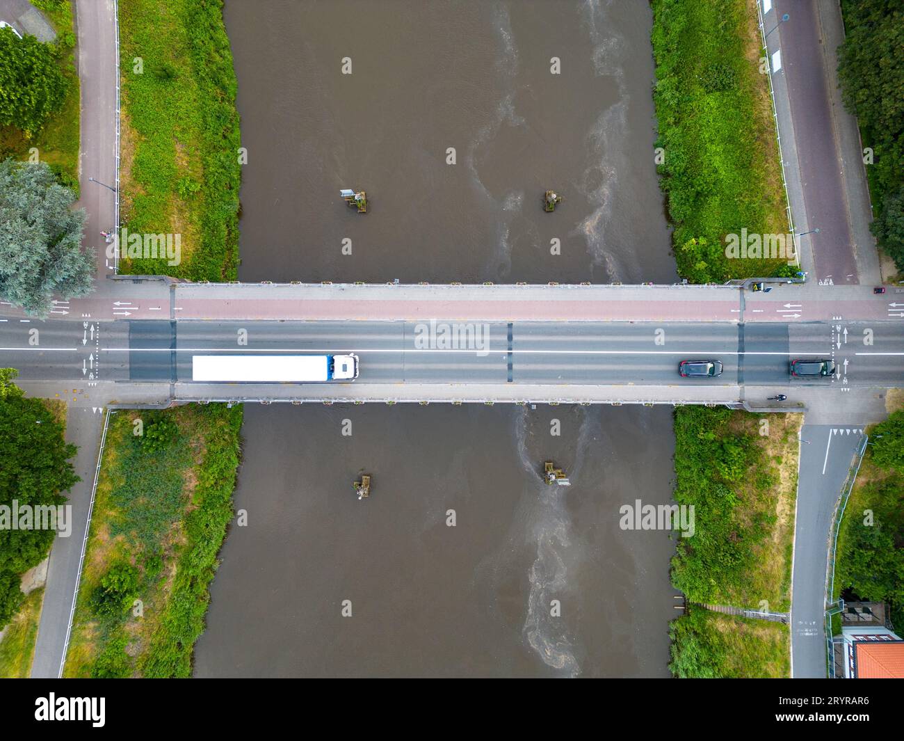 Aus der Vogelperspektive, pov direkt über der Brücke mit wenig Autoverkehr. Slow Aerial Birds Eye Overhead von oben nach unten Blick auf den tiefblauen Fluss oder Stockfoto