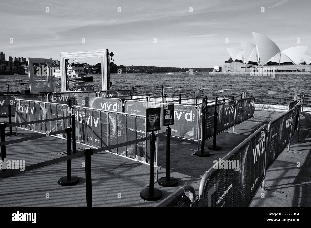 Sydney Opera House - lebendiger Sydney „Bilderrahmen“ eine Hafenfähre und ein Labyrinth aus Metallbarrikaden in Cambells Cove in Schwarz-weiß Stockfoto