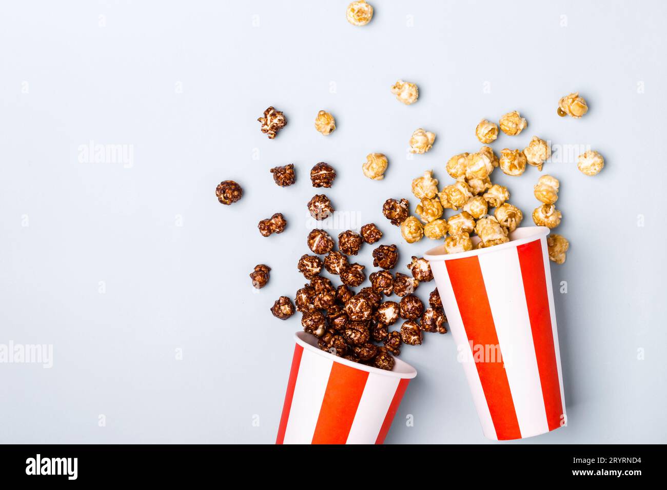Süßes Karamell-Schokoladen-Popcorn in papiergestreifter weißer roter Tasse Stockfoto